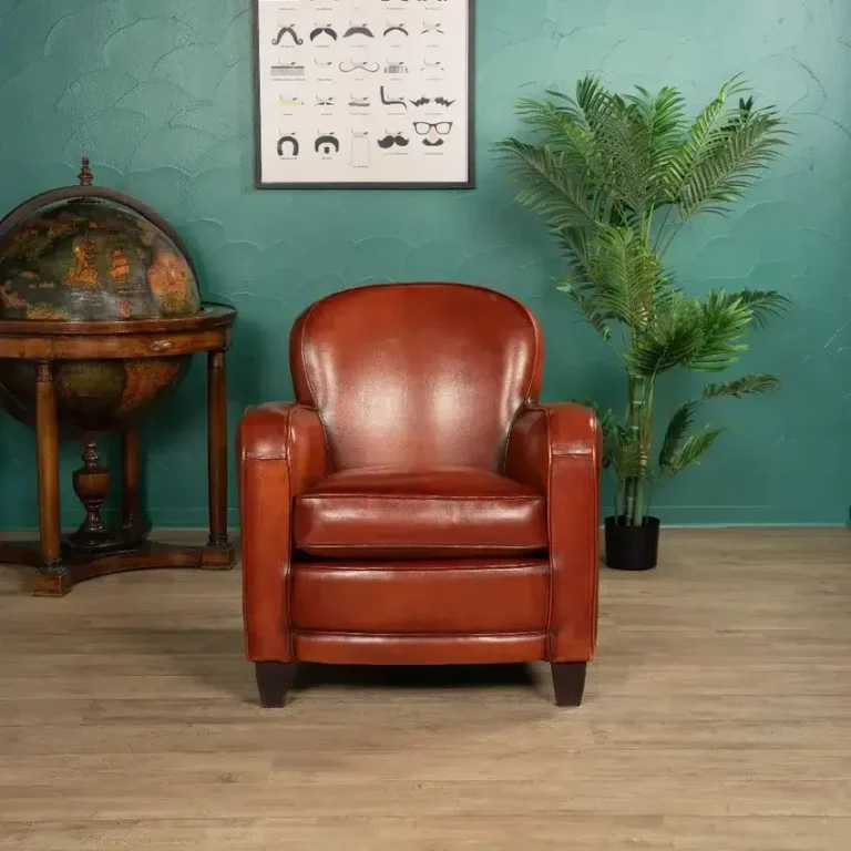 Small Bridge club armchair in cognac full-grain sheepskin leather, front view in an elegant interior setting, solid beech wood frame, handcrafted design.