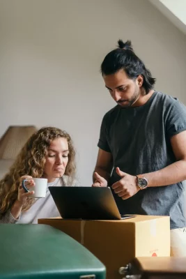 Couple discussing and choosing a leather club chair on a computer screen