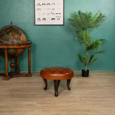 Round Chesterfield footstool in Havana full-grain leather in living room setting